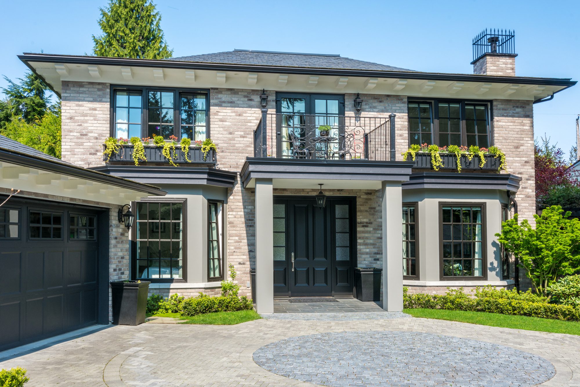 Gorgeous Luxury House With a Balcony and Beautiful Landscaping on a Sunny Day.